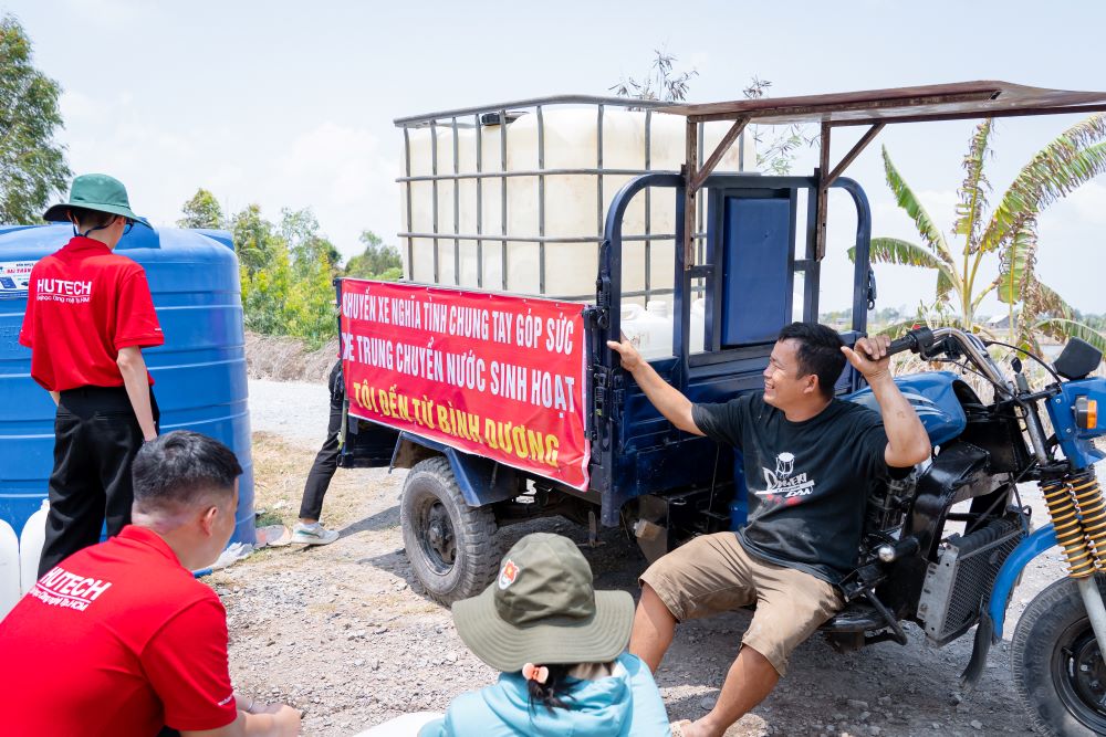 Anh Nguyễn Tấn Đạt, 41 tuổi (TP Thuận An, Bình Dương) chạy xe ba gác chạy xuống Tiền Giang giúp bà con vận chuyển nước. Ảnh: Trường Đại học Công nghệ TPHCM (HUTECH)