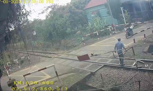 Một người điều khiển xe máy đâm vào chắn đường sắt. Ảnh cắt từ clip