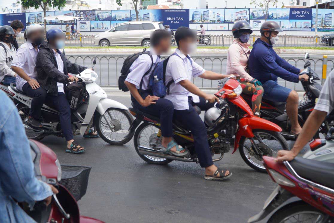 Rất nhiều học sinh vi phạm Luật Giao thông đường bộ khi điều khiển xe máy trên 50 phân khối hoặc chở quá số người quy định trên đường Kinh Dương Vương (quận Bình Tân) vào trưa 17.4. Ảnh: Chân Phúc