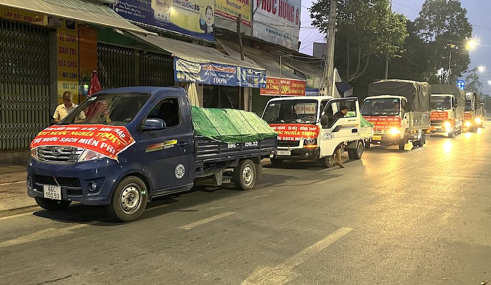 Những chiếc xe tải của nhóm nối đuôi nhau mang nước sạch đến với bà con vùng hạn mặn. Ảnh: Thanh Nghĩa