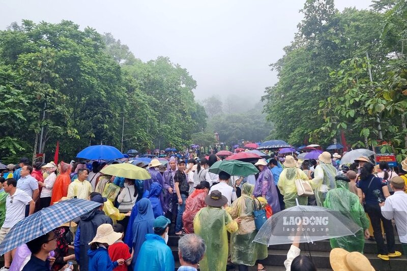 Với lượng người khá đông cộng với thời tiết có mưa, dòng người chậm rãi bước từng bước lên núi Nghĩa Lĩnh. 