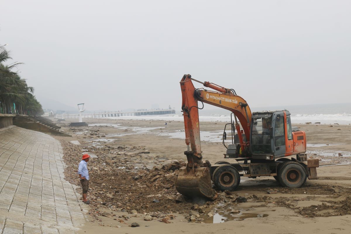 Sau phản ánh của báo Lao Động, lực lượng chức năng huyện Hoằng Hóa đã huy động máy móc đến dọn đá trên bãi biển. Ảnh: Quách Du