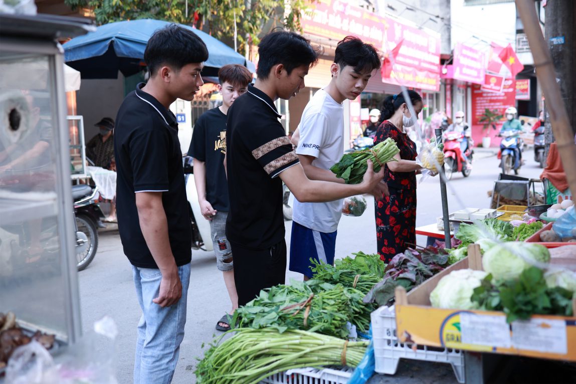 Những công nhân quê Yên Bái mua rau tại một chợ tự phát ở gần KCN Đông Anh, Hà Nội. 