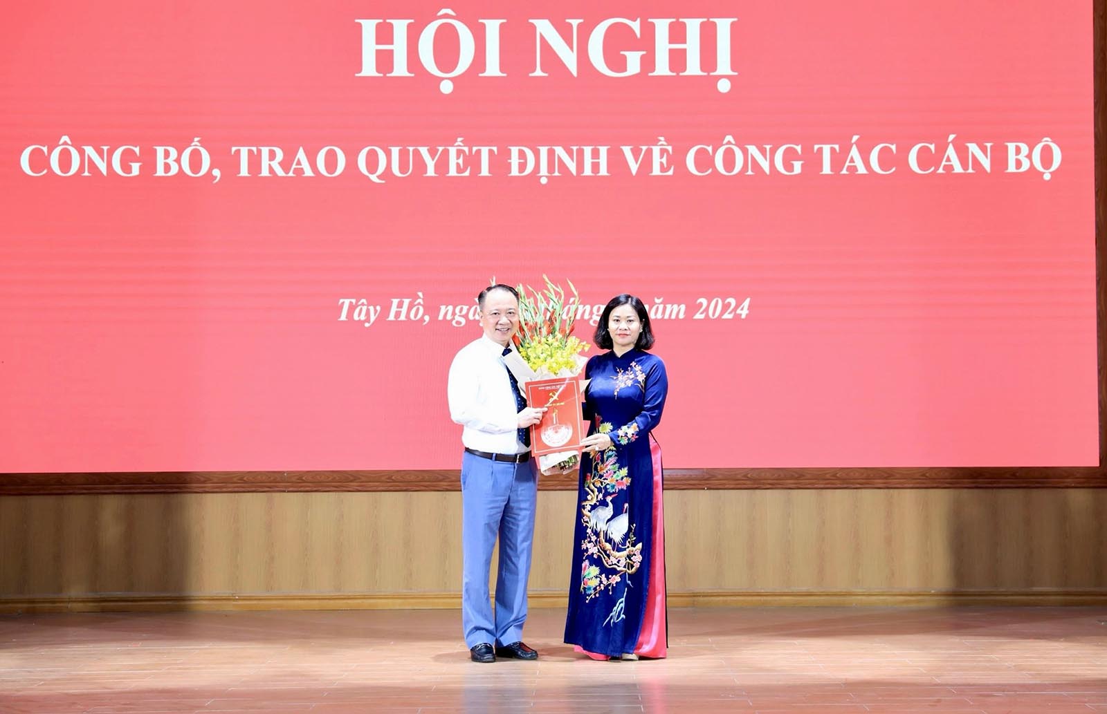 Phó Bí thư Thường trực Thành ủy Hà Nội Nguyễn Thị Tuyến trao quyết định và tặng hoa chúc mừng ông Nguyễn Lê Hoàng. Ảnh: Quang Thái