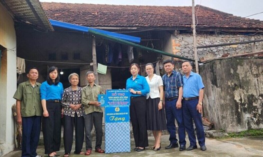 Lãnh đạo Liên đoàn Lao động huyện Mỹ Đức trao hỗ trợ cho gia đình ông Đinh Văn Tiến trong hoạt động thực hiện công tác giảm nghèo. Ảnh: CĐCS