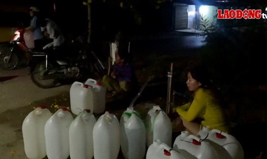 Thiếu nước ngọt trầm trọng, người dân chực chờ trong đêm lấy từng can nước ngọt về sử dụng. Ảnh: Thành Nhân