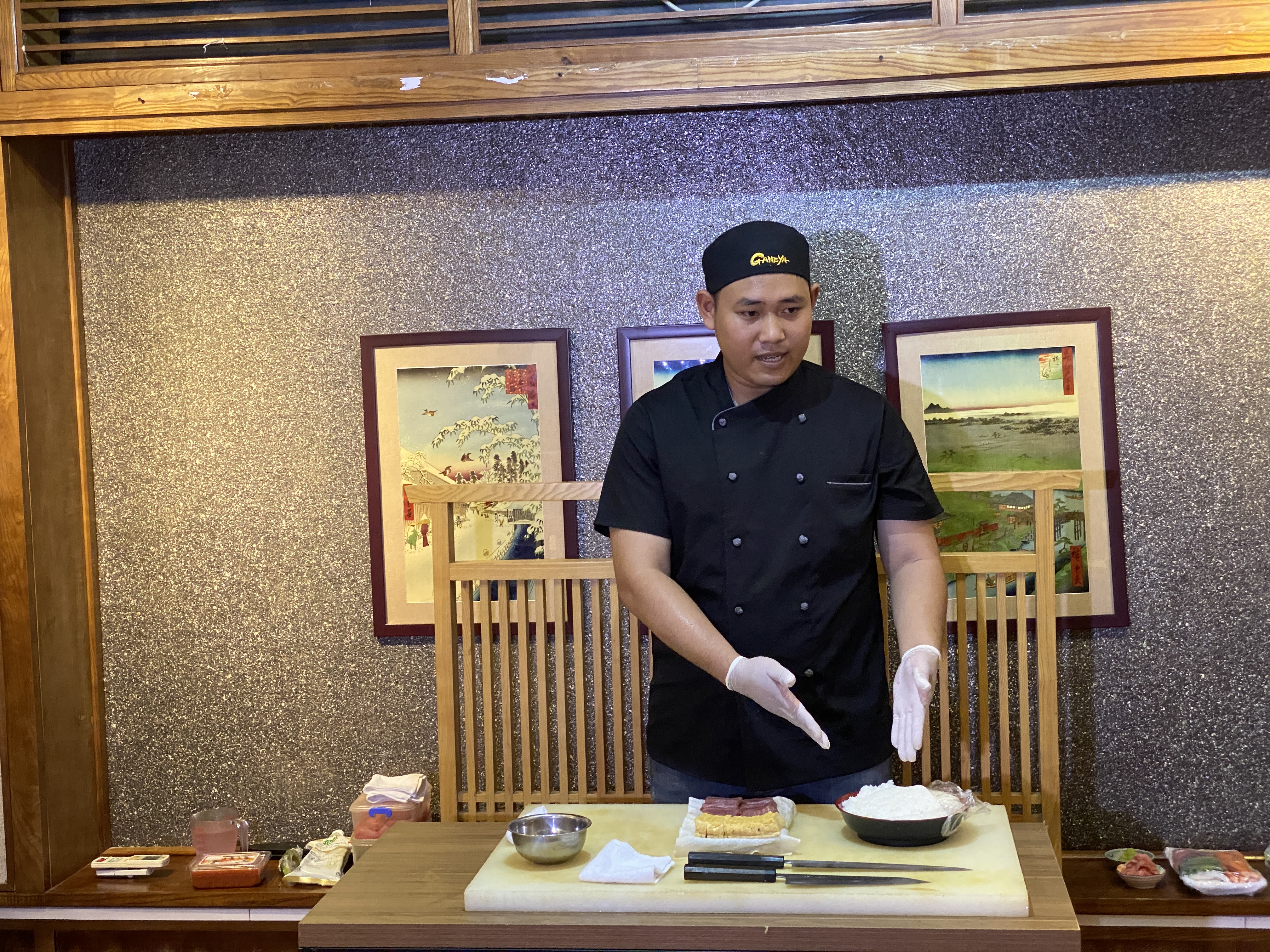 Đầu bếp sushi Trần Quang Hiệp với 7 năm kinh nghiệm làm sushi tại Nhật Bản giới thiệu về cách làm sushi dưới sự chứng kiến của giáo sư. Ảnh: Anh Vũ