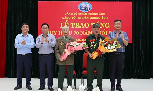 Thường trực Đảng bộ huyện Mường Ảng, tỉnh Điện Biên tặng hoa chúc mừng 2 chiến sĩ Điện Biên nhận Huy hiệu 70 năm tuổi Đảng. Ảnh: Lê Lan