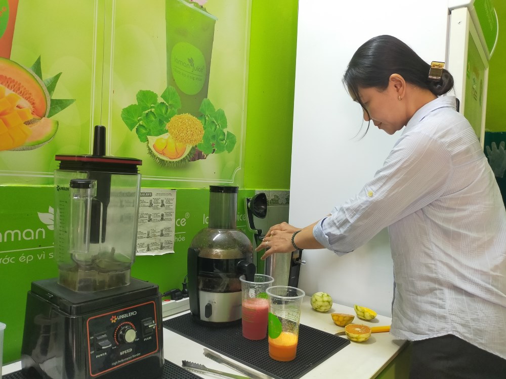 Chị Nguyễn Thị Thúy bán nước ép xuyên trưa để phục vụ khách vào tránh nóng ở Quận 11. Ảnh: Minh Tâm