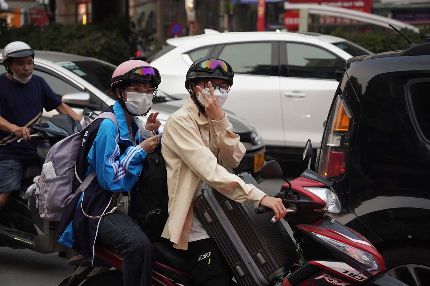 người dân mặc áo chống nắng, vừa chở theo đồ đạc trên xe máy để về quê.