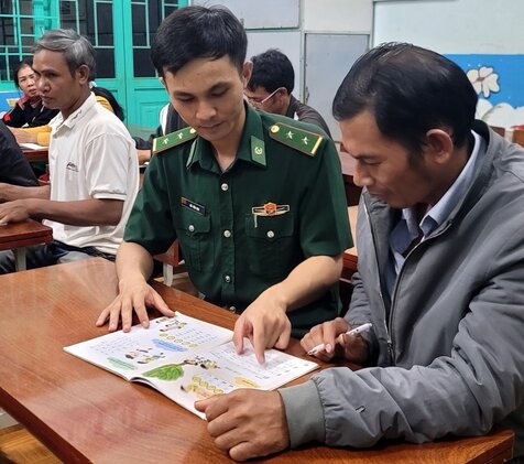 Các chiến sĩ Bộ đội Biên phòng ở Đắk Nông truyền lửa giúp bà con vùng biên giới xã Thuận An tham gia lớp học xóa mù chữ. Ảnh: Hồng Thắm