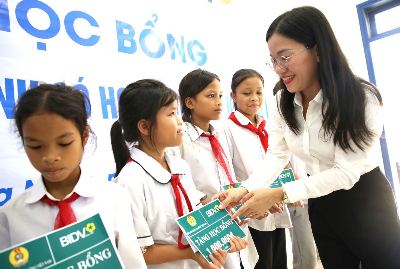Đại diện Ngân hàng TMCP Đầu tư và Phát triển Việt Nam chi nhánh tỉnh Quảng Trị trao học bổng cho các cháu học sinh. Ảnh: Hưng Thơ.