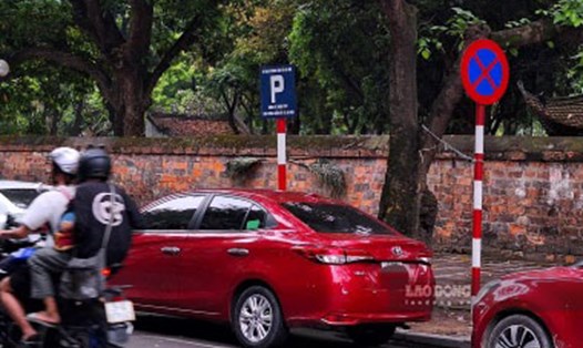 Biến cấm đỗ liền liền kề với biển điểm trông giữ xe tại đường Văn Miếu. Ảnh: Đền Phú