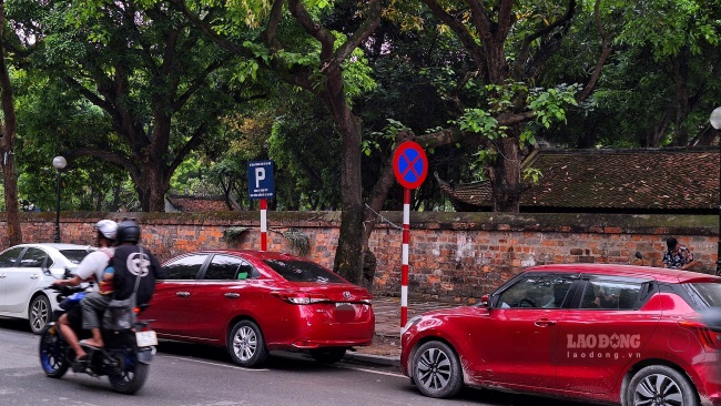 Trên tuyến phố Văn Miếu có 3 biển cấm dừng đỗ xen kẽ với 3 biển thông báo điểm đỗ xe của công ty TNHH MTV Khai thác điểm đỗ xe Hà Nội. Ảnh: Đền Phú