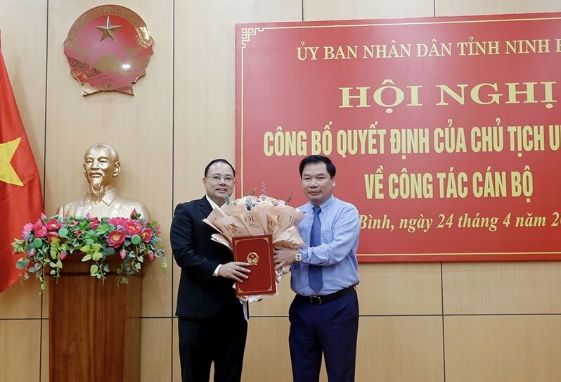 Ông Tống Quang Thìn, Phó Chủ tịch Thường trực UBND tỉnh trao quyết định, tặng hoa cho đồng chí Vũ Văn Vĩnh. Ảnh: Quỳnh Trang