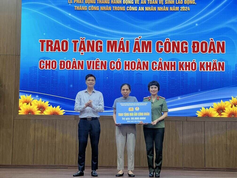 Ông Ngọ Duy Hiểu và bà Công Thanh Thảo - Trưởng Ban Công đoàn CAND trao Mái ấm Công đoàn cho đoàn viên khó khăn. Ảnh: Minh Hương.