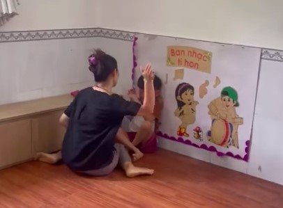Cô giáo dồn trẻ vào góc tường, đánh liên tiếp vào người trẻ. Ảnh: Cắt video