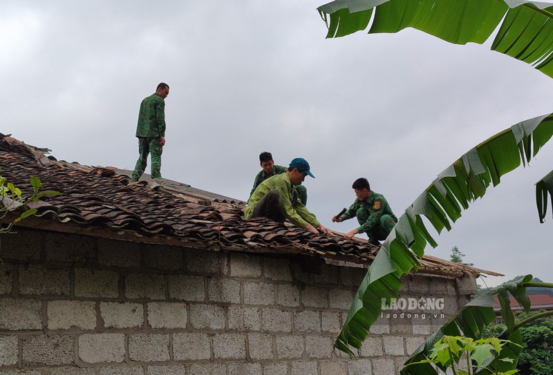 Chiến sĩ Đồn Biên phòng cửa khẩu Lý Vạn giúp đỡ người dân khắc phục hậu quả thiên tai, sửa mái nhà. Ảnh: Tân Văn.