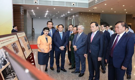 Phó Thủ tướng Chính phủ Trần Lưu Quang và các đại biểu tham quan triển lãm ảnh tại lễ kỷ niệm “70 năm ngày ký Hiệp định Geneve về đình chỉ chiến sự ở Việt Nam” ngày 25.4. Ảnh: Hải Nguyễn