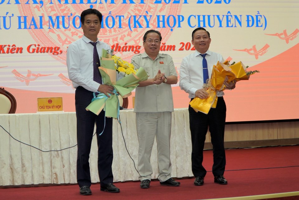 Ông Mai Văn Huỳnh, Chủ tịch HĐND tỉnh tặng hoa cho ông Lê Quốc Anh (bìa trái) và ông Lê Hữu Toàn (bìa phải). Ảnh: Nguyên Anh
