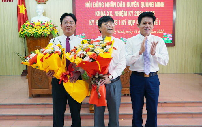 Ông Phạm Trung Đông (bìa trái) và ông Nguyễn Ngọc Thụ (bìa phải) nhận hoa chúc mừng chức vụ mới. Ảnh: Nguyên Bảo