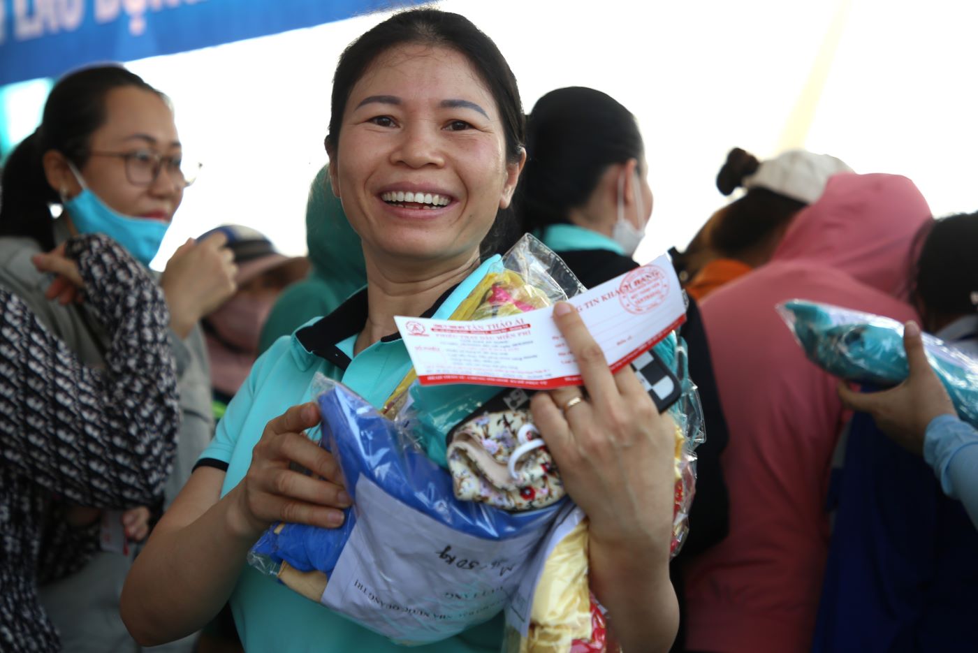 Nữ công nhân vui mừng khi nhận được quà tặng là bộ áo dài. Ảnh: Hưng Thơ