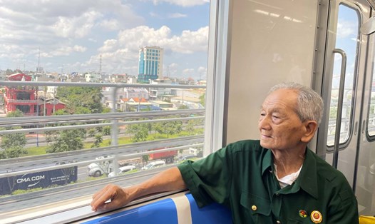 Cựu chiến binh Trịnh Hữu Cán (93 tuổi) ngắm TPHCM từ trên cao qua khung cửa Metro số 1.  Ảnh: Minh Quân