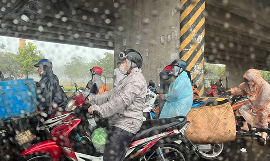 Các phương tiện dừng đỗ để trú mưa dưới gầm cầu vượt tại nút giao IC3 đường dẫn cầu Cần Thơ đã gây ra tình trạng ùn tắc giao thông. Ảnh: Uyên Ly