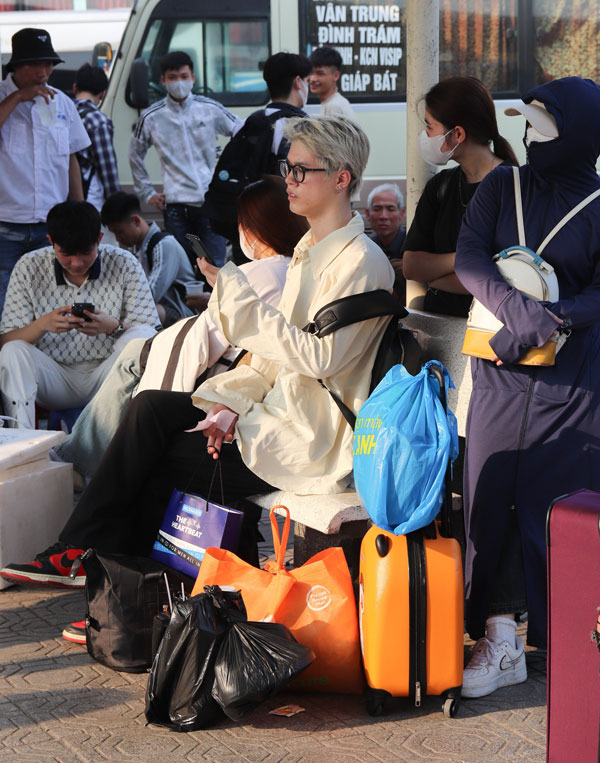 Người dân mang theo nhiều đồ đạc, hành lý để chuẩn bị lên xe rời Hà Nội nghỉ lễ. Chờ đợi lâu trong thời tiết nắng nóng khiến nhiều người càng thêm mệt mỏi. Ảnh: Linh Xuyến