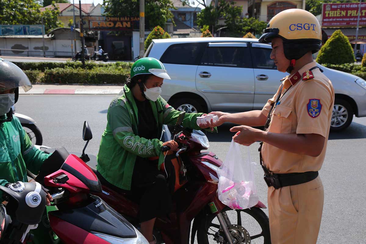 Dưới thời tiết nắng gắt, người dân đi xe máy nhận quà cảm thấy mát lòng vì những chai nước miễn phí để “giải nhiệt”. 