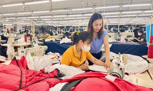 Chị Lê Thị Bích (áo xanh) hỗ trợ công nhân trong quá trình sản xuất. Ảnh: Nhân vật cung cấp