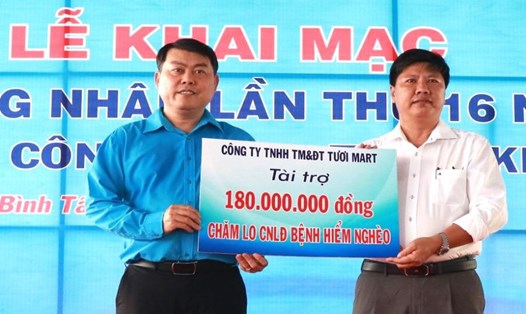 Ông Nguyễn Văn Hải - Chủ tịch LĐLĐ Quận Bình Tân (bên trái) - tiếp nhận hỗ trợ của Công ty TNHH Thương mại và Đầu tư Tươi Mart cho các công nhân bị bệnh hiểm nghèo. Ảnh: Đức Long
