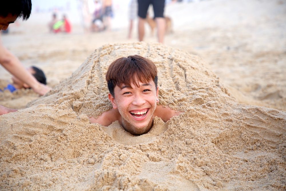 Trước khi tắm biển, nhiều bạn trẻ chọn trò chơi đắp cát làm thú vui. Ảnh: Công Sáng