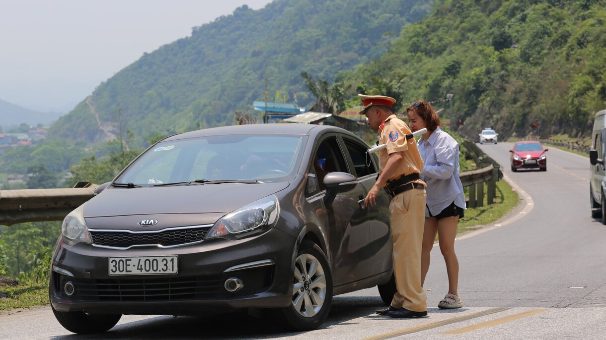 CSGT Hòa Bình giúp đỡ người nữ tài xế ôtô gặp sự cố xe chết máy dưới nắng nóng lúc giữa trưa. Ảnh: Minh Nguyễn