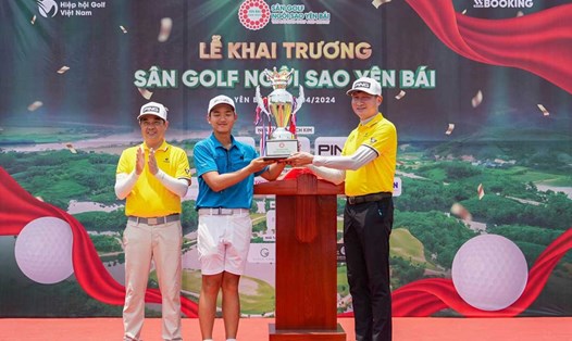 Chủ tịch UBND tỉnh Yên Bái Trần Huy Tuấn (phải) trao cúp vô địch cho golfer trẻ Nguyễn Anh Minh. Ảnh: Ban tổ chức.