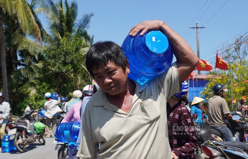 Người dân ở cù lao Tam Hiệp (huyện Bình Đại, tỉnh Bến Tre) được tặng bình nước tinh khiết. Ảnh: Thành Nhân