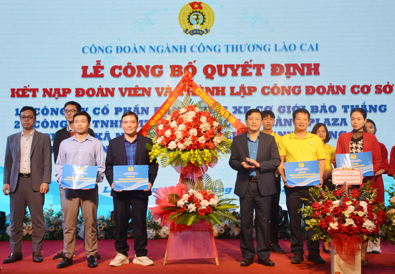 Lãnh đạo Liên đoàn Lao động tỉnh Lào Cai trao quyết định, tặng hoa chúc mừng các công đoàn cơ sở mới được thành lập. Ảnh: Lan Hương