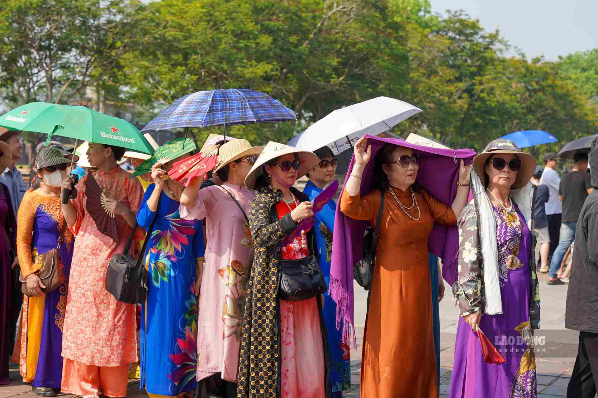 Một tay cầm nước, một tay cầm ô, trên đầu là những vật dụng che nắng như ô, nón, khăn trùm, đó là hình ảnh của hàng ngàn du khách đổ về khu vực Đại Nội Huế ngày hôm nay 28.4. 