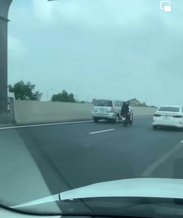 Hai người đi xa máy vào làn tốc độ 120km/h trên đường cao tốc Hà Nội - Hải Phòng ngày 24.4. Ảnh cắt từ Clip