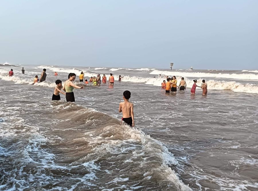 Người dân, du khách tắm biển Cồn Vành giải nhiệt trong chiều ngày 28.4. Ảnh: Nam Hồng