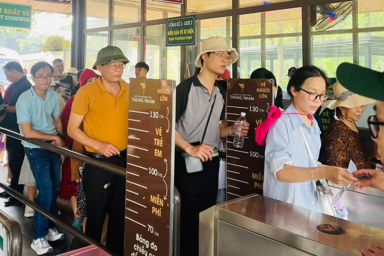 Du khách xếp hàng mua vé tham quan tại Khu du lịch sinh thái Thung Nham. Ảnh: Nguyễn Trường