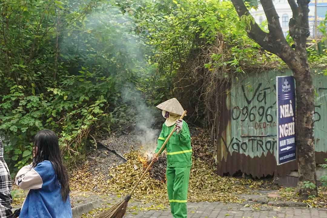 Công nhân vệ sinh môi trường vẫn phải đeo khẩu trang kín mít để làm việc dưới thời tiết oi bức. Ảnh: Nhật Minh