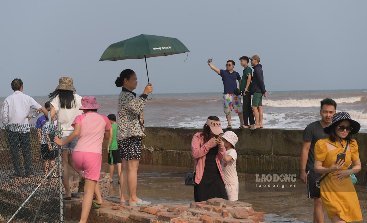 Đáng nói, nhiều người bất chấp nguy hiểm trèo lên hàng rào chắn sóng để chụp ảnh.