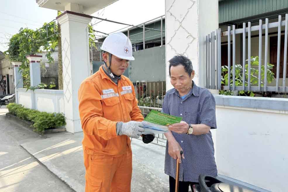 Cán bộ điện lực Hà Tĩnh tuyên truyền với người dân sử dụng điện an toàn, tiết kiệm. Ảnh: Thảo Tuấn.