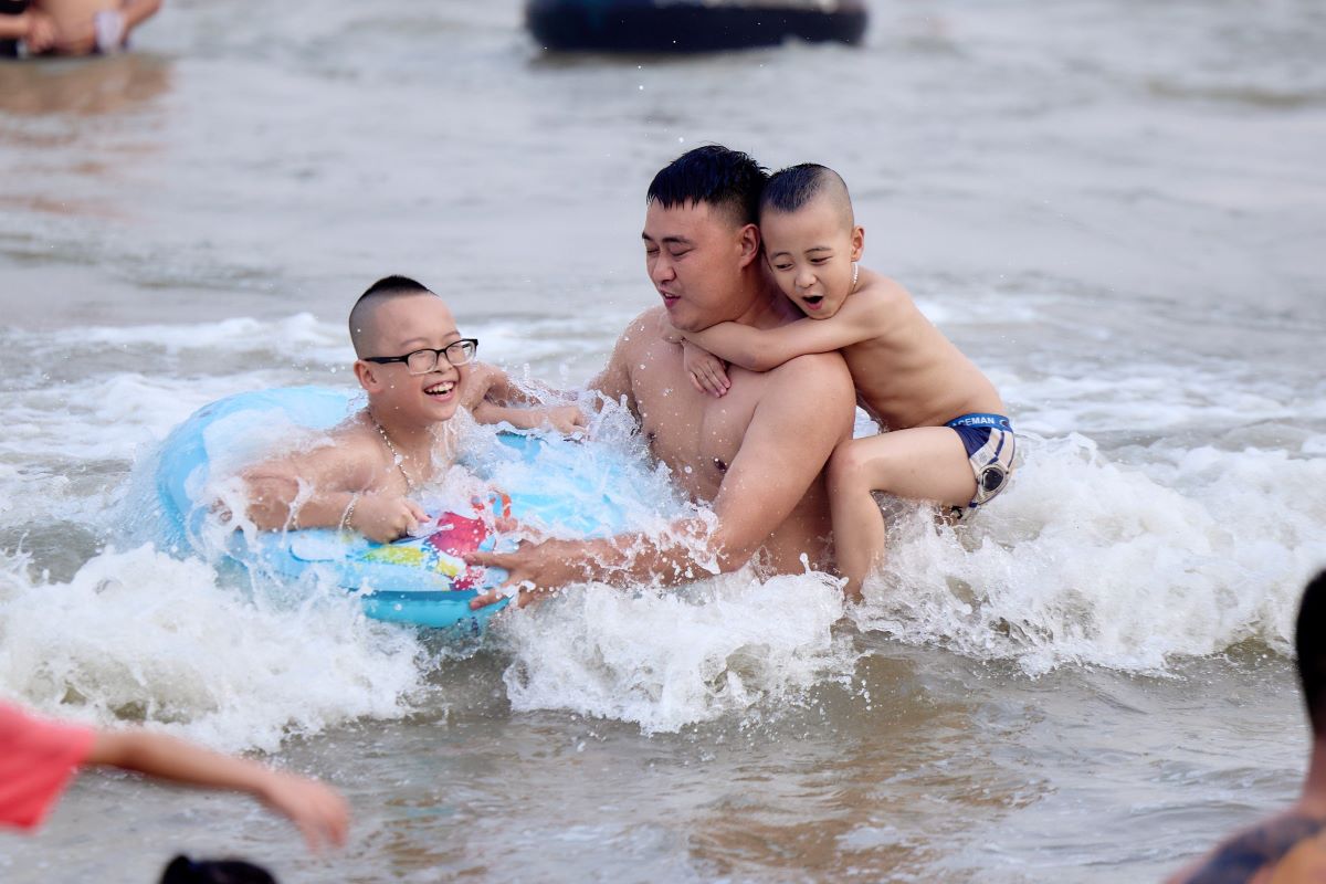 Các gia đình cho con nhỏ về tắm mát tại biển Sầm Sơn chiều ngày 29.4. Ảnh: Quách Du