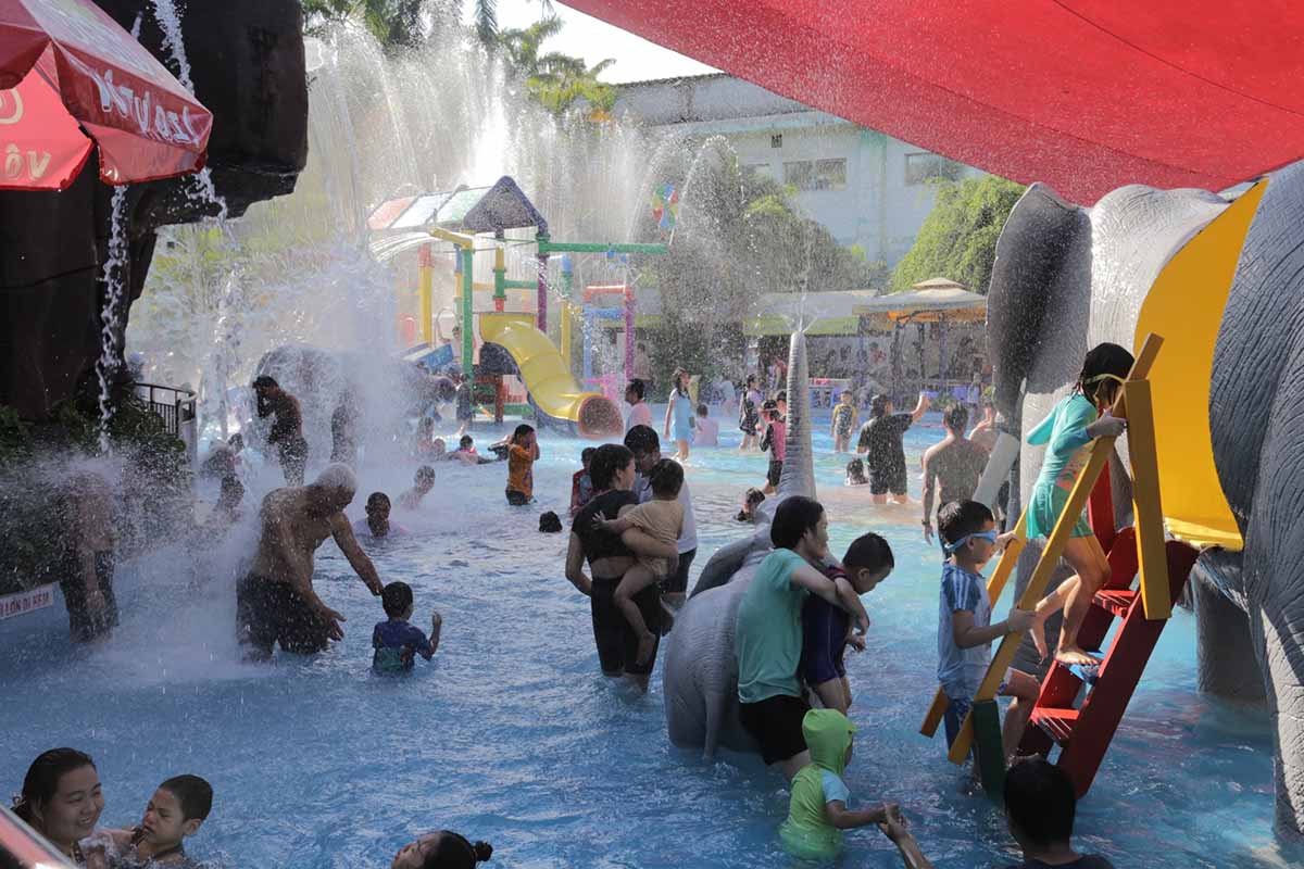 Các bạn trẻ thích thú vui chơi dưới làn nước mát trong công viên nước. 