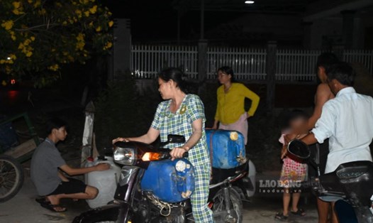 Người dân ở xã Tân Điền (huyện Gò Công Đông, tỉnh Tiền Giang) đem can đến vòi nước công cộng lấy nước vào ban đêm. Ảnh: Thành Nhân