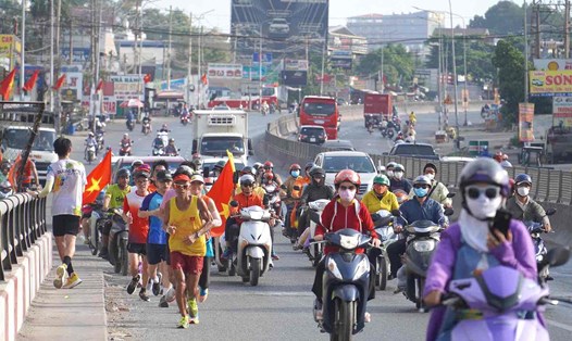Những bước chạy của dị nhân Marathon Nguyễn Văn Long (người chạy đầu tiên) trên Quốc lộ 1 đoạn qua TP Biên Hòa (Đồng Nai). Ảnh: HAC