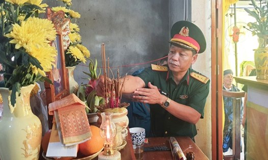 Thượng tá Phan Thắng - Chỉ huy trưởng Bộ CHQS tỉnh TT-Huế, thắp hương phúng viếng mẹ của chiến sĩ bị tử vong do giông sét. Ảnh: Lê Sáu.