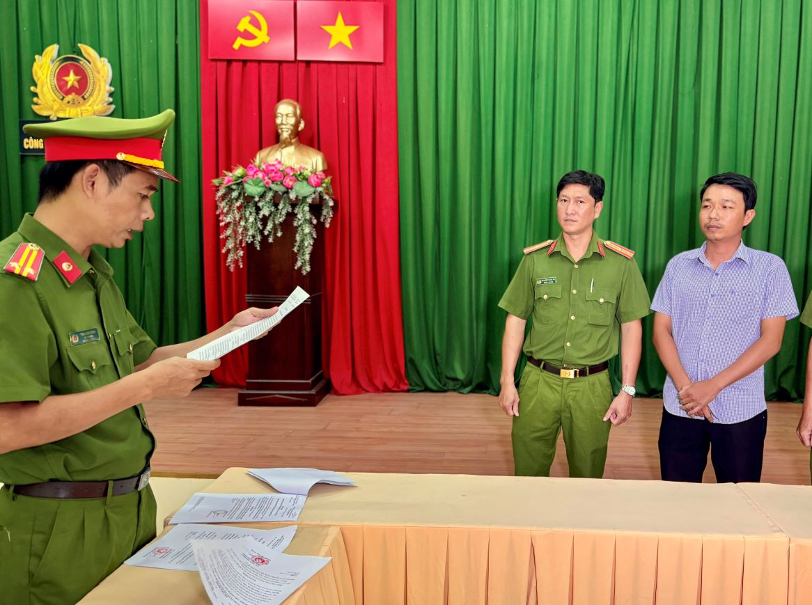 Cơ quan Công an đang tống đạt các quyết định khởi tố đối với bị can Phạm Quang Vinh ( thứ nhất từ phải sang). Ảnh: Vũ Tiến 